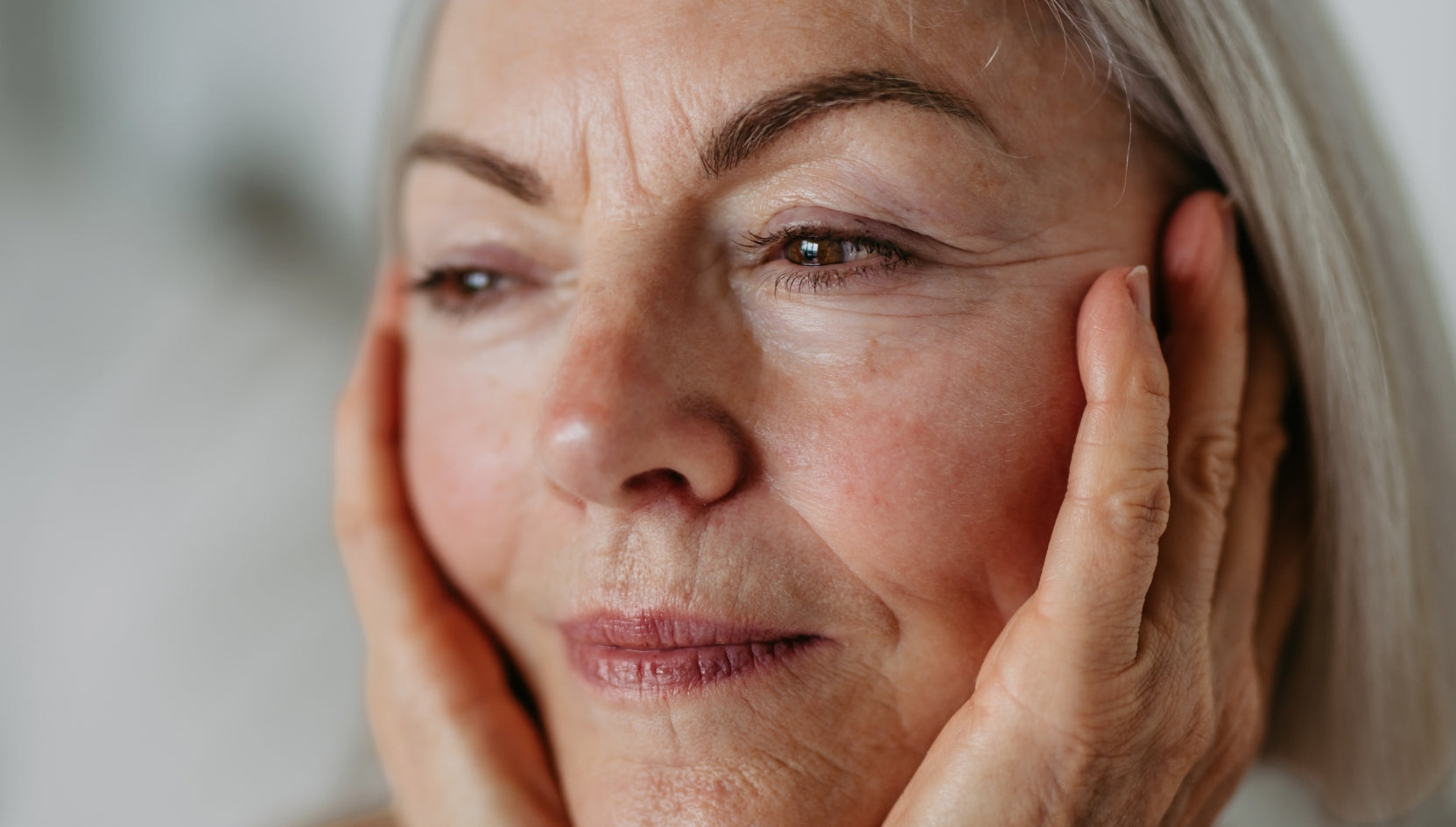 Kvinde kigger på sine rynker i et spejl