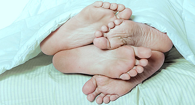 To par fødder stikker ud af en dyne